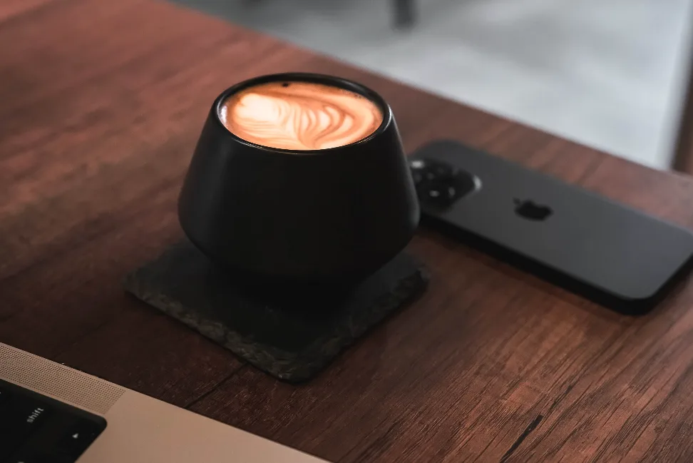 Café Cofaine en casa, junto a la laptop y el teléfono