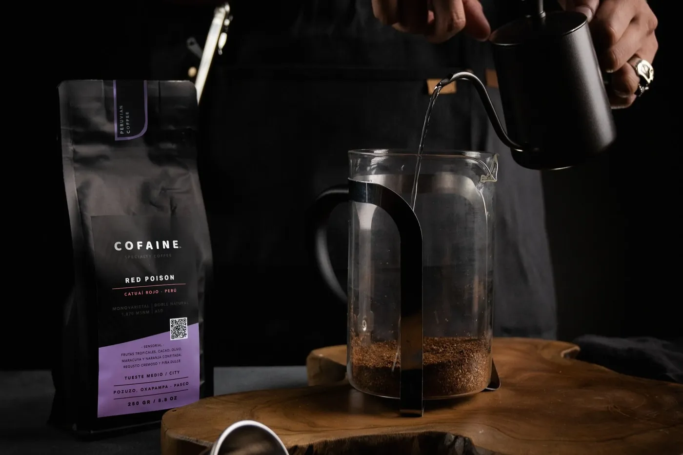 Prensa francesa y bolsa de café Cofaine sobre la mesa